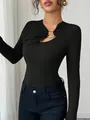 Détail de l'encolure asymétrique avec anneau en métal doré sur haut noir ajusté - S / Hauts / Noir