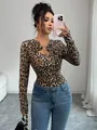 Close-up of leopard print long-sleeve top with asymmetric cutout and metal ring. - Leopard Print