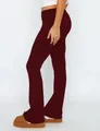 A detailed side view of burgundy low-waisted flare pants featuring a fold-over waistband - Burgundy