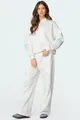 Model wearing a white oversized hooded tracksuit set with blue bow sleeve details - S / Top And Bottom / White