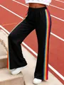 Detailed view of women's black casual pants featuring vibrant rainbow side stripes. - S / Bottoms / Black
