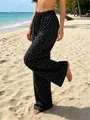 Detailed shot of women's high-waisted leopard print leisure pants at the beach - S / Bottoms / Black