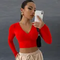 Detalle de un top corto rojo de manga larga con cuello en V y tejido acanalado - S / Tops / Rojo