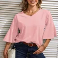 Detail of a pink V-neck t-shirt with bell sleeves on a female model outside - Pink