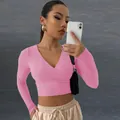 Gros plan d'un crop top rose sexy à col en V et manches longues porté par un mannequin - Rose Pourpre