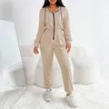 Vista completa della tuta beige da donna con cappuccio in uno studio bianco - Kaki