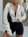 Detalle de una sudadera corta gris con capucha y cremallera para un estilo casual - S / Tops / Gris claro