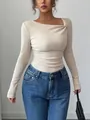 Close-up detail of beige ribbed long-sleeve top featuring an asymmetrical ruched neckline design - Apricot