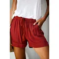Close-up of women's high-waisted casual shorts with drawstring waist and pockets in rust red - S / Bottoms / Burgundy