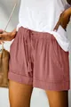 Dettaglio ravvicinato di pantaloncini rosa polvere a vita alta con coulisse e tasche. - Rosa