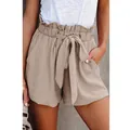 Close-up of stylish paper-bag waist shorts with tie-belt and side pockets in beige - Apricot