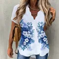 Detail of a white short-sleeve blouse with blue floral print and scalloped V-neck design. - S / Tops / Blue