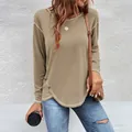 Close-up detail of a women's khaki long sleeve T-shirt featuring an irregular buttoned hem. - Khaki