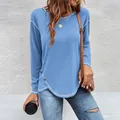 Detail view of blue long sleeve t-shirt with irregular hem and button accents - S / Tops / Light Blue