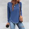 Detail view of blue long sleeve tee featuring irregular hem with buttons and white stitching - S / Tops / Dark Blue