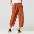 Detail shot of women's loose rust-colored casual long pants with comfortable elastic waist - S / Bottoms / Orange