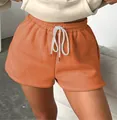 High-waisted orange drawstring sweat shorts for women in a casual and trendy summer style - Orange