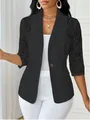 Détail du blazer noir avec des manches en dentelle délicate et un bouton rose doré. - Noir