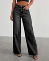 Detail view of high-waisted wide-leg jeans with unique side seams and frayed hem. - S / Black