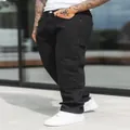 Men's loose black patchwork denim jeans with comfortable fit styled with white sneakers - XL=34 / Bottoms / Black