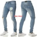 Dettaglio dei jeans da uomo azzurro slim fit con strappi e trama del tessuto - Taglia S / Pantaloni e gonne / Azzurro