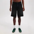 Men's black denim shorts on model, styled with white socks and green retro sneakers. - S / Bottoms / Black