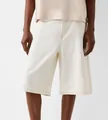 Detail view of men's loose-fit off-white denim shorts with clean stitching. - White