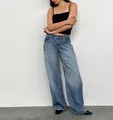 Detail view of women's vintage low-rise wide-leg washed denim jeans in street style - XS / Bottoms / Mid Blue (207)