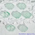 Detail view of green carved cloud glass beads for DIY jewelry making, size 9x13x4mm - Liuli Auspicious Cloud (L562) / Light Green