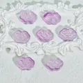 Detail view of purple cloud-shaped translucent glass beads with traditional patterns. - Liuli Auspicious Cloud (L573) / Purplish Red