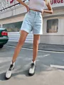 Trendy women's high-waisted loose fit denim shorts featuring a light blue wash finish - Blue & White