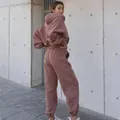 Vue arrière détaillée d'un survêtement mauve oversize élégant sur fond de mur en béton - S / Haut Et Bas / Vieux rose