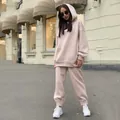 Stylish women's beige oversized hoodie and jogger pants tracksuit set in street setting. - Apricot