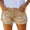 Close-up detail of women's distressed tan denim shorts with frayed hem and multi-button fly - Camel