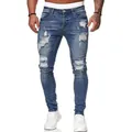 Close-up view of men's slim-fit distressed blue jeans with stylish ripped details. - Medium Blue