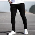 Vue détaillée du jean stretch noir coupe slim pour homme avec baskets blanches - S (28) / Bas / Noir