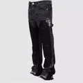 Detailed view of men's stacked flare jeans with white paint splatter and patchwork design - L / Bottoms / Black and Gray