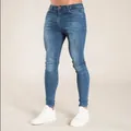Men's slim fit blue skinny jeans shown with white sneakers on a plain background - S / Bottoms / Dark Blue
