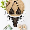 Detailed view of elegant black lace bikini set featuring floral pattern and halter string ties - S / Top And Bottom / Black Lace and Nude