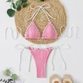 Detail view of a pink ribbed bikini set with white lacing on a straw mat background. - S / Top And Bottom / Pink
