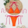 Detailed view of orange ribbed bikini with neon pink lace-up ties and eyelet accents - S / Top And Bottom / Orange Red
