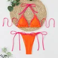 Detailed view of orange ribbed bikini with neon pink lace-up ties and eyelet accents - S / Top And Bottom / Orange Red