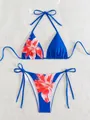 Flat lay of blue two-piece bikini set with vibrant red floral print and side ties - S / Top And Bottom / Red Floral on Dark Blue