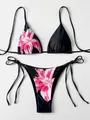 Detailed view of a black two-piece bikini set featuring a vibrant pink lily floral print. - S / Top And Bottom / Red Floral on Black