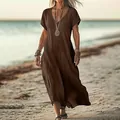 Elegant brown loose V-neck cotton linen maxi dress worn on a beautiful sunny beach day - Coffee