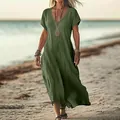 Detailed view showing the loose fit of a green V-neck cotton linen maxi dress on a beach. - Army Green