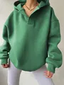 Close-up detail of green oversized hoodie with V-neck hood and ribbed cuffs fabric - Green