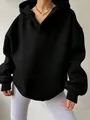 Detailaufnahme eines schwarzen Oversize-Hoodies mit V-Ausschnitt und Rippbündchen. - S / Oberteile / Schwarz