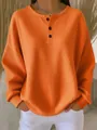 Close-up of orange waffle knit long sleeve pullover with buttoned crew neck and loose fit - S / Tops / Orange