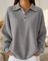 Detailed view of women's grey waffle knit long sleeve polo shirt with lapel collar - Gray